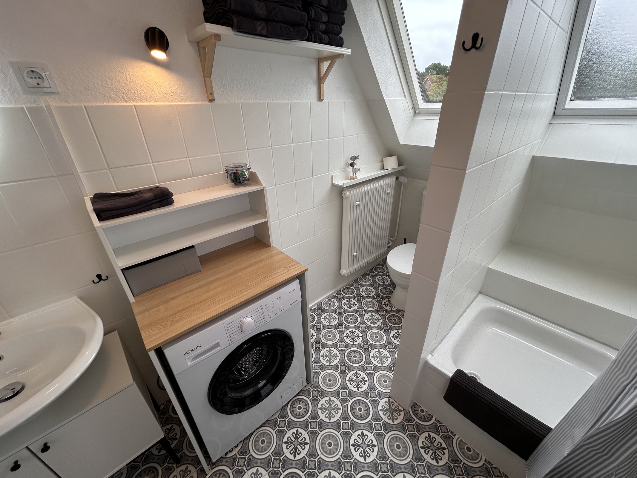 Badezimmer mit Dusche und Waschmaschine in Ferienwohnung 4