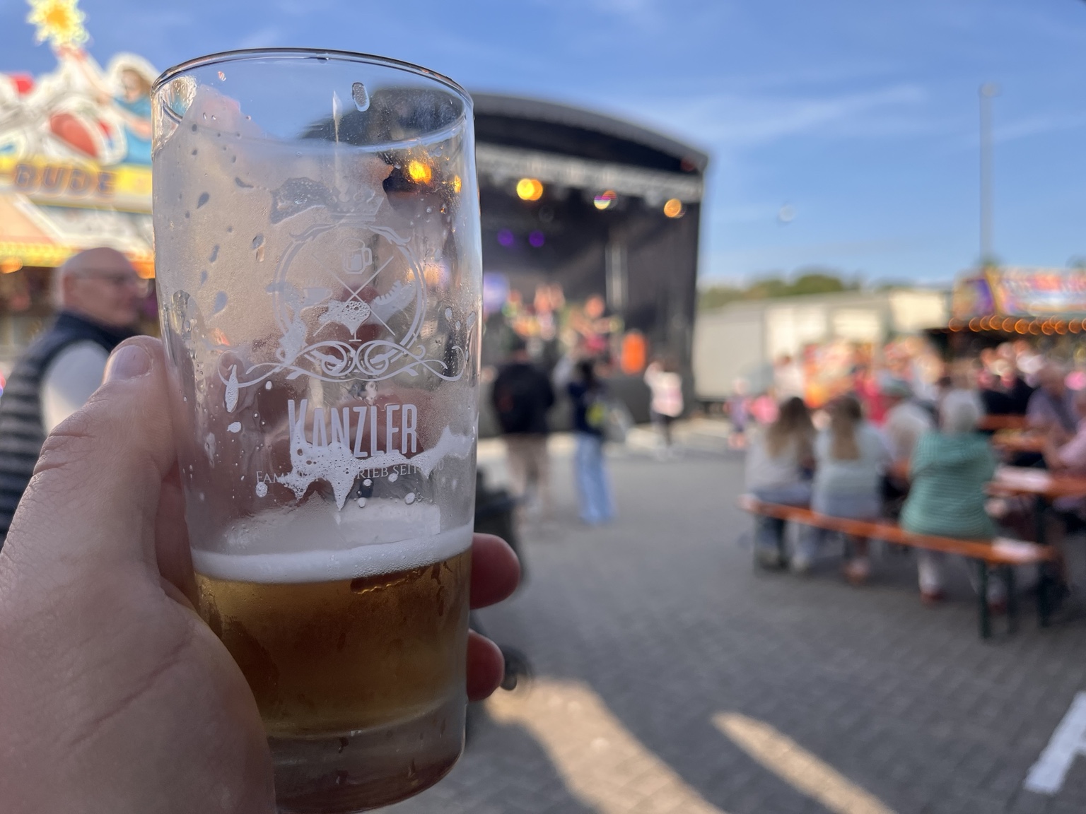 Bierglas vor der unscharfen Bühne beim Strand- und Hafenfest Bensersiel 2026